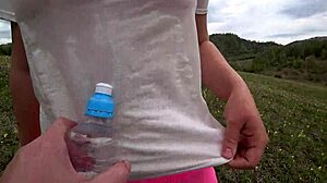 Lesbian shoves bottle deep in girlfriend's wet hairy pussy doggystyle outdoors
