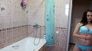 A girl with big tits and a shaved pussy washes under the shower
