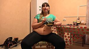 A beautiful bbw in leggings and with a big belly eats and shakes a thick stomach home fetish