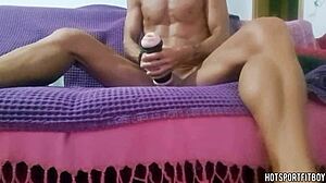 this muscular guy is moaning loud as he humps a fleshlight on the couch, cumming inside.