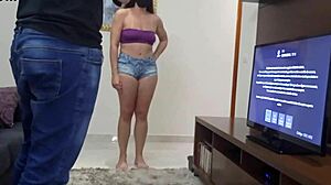 Curvy barefoot housewife teases TV technician with short shorts, exposing shaved pussy and natural tits