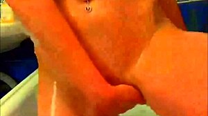 Tattooed model intensely fingers glass dildo in bathroom