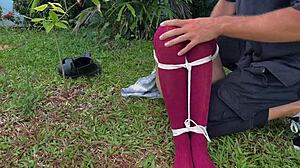 Caressing dirty socks on bound blonde outdoors.