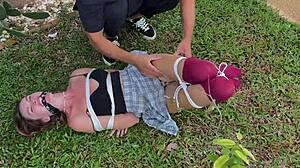 Caressing dirty socks on bound blonde outdoors.