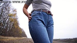 The milf teases her big cameltoe in tight blue jeans outdoors