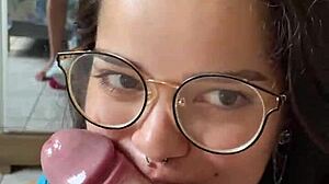 Nerdy brunette girlfriend gives deep blowjob to big cock in shorts, contrasting beauty with passion