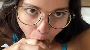 Nerdy brunette girlfriend gives deep blowjob to big cock in shorts, contrasting beauty with passion