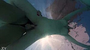 Underwater, two lesbians strap on and fuck passionately