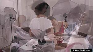 Photographer casually fucks the girl with a strap-on during the intimate photoshoot