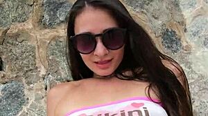 cute brunette babe chills in bikini flashing at public beach