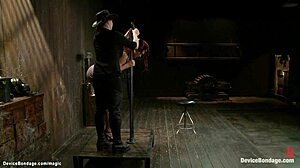 Redhead slave trapped neck-deep in kinky bondage device