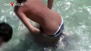amateur couple sneaks quick fuck in ocean waves on crowded public beach