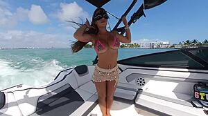 sun-kissed brunette in bikini flashes huge fake tits and thong on boat deck