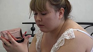 Visage magnifique de MILF ronde en tenue sexy peignant ses lèvres en coulisses