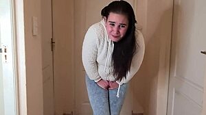 Desperacka młoda sikająca w ciasne dżinsy i ciepłą kurtkę