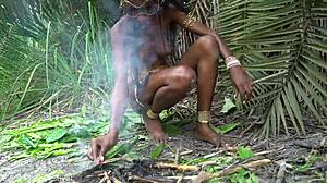 Varm afrikansk indfødt kvinde laver mad alene i junglen